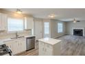 Modern kitchen and living room with stainless steel appliances, island and hardwood flooring throughout at 4060 Rockmill Cv, Ellenwood, GA 30294