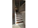 Staircase with wooden stairs, white risers and railing leading to the kitchen at 1325 Classic Ne Dr, Conyers, GA 30013
