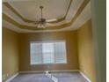 Bedroom with tray ceiling, neutral color walls, carpet flooring, and a ceiling fan at 9996 Village South Dr, Douglasville, GA 30135