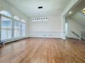 Bright living room featuring hardwood floors, large windows, and modern chandelier at 8630 Moor Park Run, Duluth, GA 30097