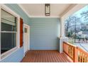 Inviting front porch featuring painted wood ceiling, wood decking, and modern light fixture at 1057 Regent Sw St, Atlanta, GA 30310