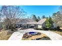 An elegant home with a circular driveway, a beautiful stone fountain, and a well-manicured lawn at 2150 Fincher Rd, Canton, GA 30114