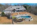 A luxurious pool and spa are surrounded by lush landscaping and stone terraces, creating a private outdoor oasis at 2150 Fincher Rd, Canton, GA 30114