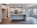 Kitchen displaying granite countertops, white cabinetry, stainless steel appliances, and hardwood floors at 3017 Abelia Dr, Buford, GA 30519