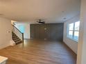 Spacious living room with wood floors, a modern ceiling fan, and large windows providing plenty of natural light at 3037 Abelia Dr, Buford, GA 30519