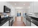 Galley kitchen featuring stainless steel appliances and black countertops at 418 Lantern Wood Dr, Scottdale, GA 30079