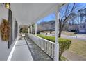 Inviting front porch featuring white columns, a railing, and views of the neighborhood street at 1938 Kelvin Dr, Lawrenceville, GA 30043