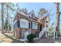 Attractive brick home featuring a front porch, rooftop deck, and well-manicured landscaping at 238 Howell Sw Dr, Atlanta, GA 30331