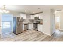 Bright kitchen with stainless steel appliances, granite counters, white cabinetry, and wood-look floors at 2631 Santa Barbara Nw Dr, Atlanta, GA 30318