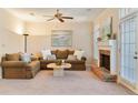 Comfortable living room featuring a brick fireplace, neutral tones, ceiling fan, and a sliding glass door to the exterior at 312 River Glen Dr, Roswell, GA 30075