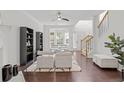 Bright living room with modern furnishings, hardwood floors, and large windows offering ample natural light at 112 Timber Mist Ln, Lawrenceville, GA 30045