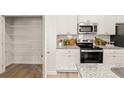 Well-equipped kitchen features granite countertops, modern appliances, subway tile backsplash, and a spacious pantry at 344 Sinclair Ct # 74, Mcdonough, GA 30253