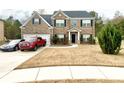 Charming two-story brick home featuring a two-car garage and well-manicured lawn at 1291 Vienna Ct, Hampton, GA 30228