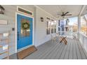 Inviting covered front porch with a blue door, ceiling fan, and seating area at 1591 Alder Se Ct, Atlanta, GA 30317