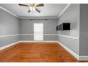 Living room features hardwood floors, light-colored walls, a ceiling fan, and a large window for natural light at 1450 Brandy Shoals Se Dr, Conyers, GA 30013