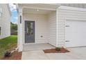 Two-story home's entrance and garage, with manicured landscaping at 2025 Wyndham Pl, Conyers, GA 30013