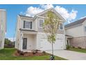 Two-story home with a two-car garage, and a well manicured front yard at 2025 Wyndham Pl, Conyers, GA 30013