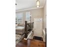 Welcoming foyer with hardwood floors, staircase and entry door to townhome interior at 4447 Kerrington Ave, Sugar Hill, GA 30518