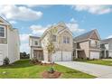 Inviting home with a two-car garage, modern facade, complemented by a green lawn and young tree at 2027 Wyndham Pl, Conyers, GA 30013