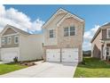 Beautifully designed home with a two-car garage, brick and siding combination, and a green lawn at 2027 Wyndham Pl, Conyers, GA 30013