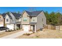 Exterior side view featuring a neutral-colored two-story home, complemented by a well-maintained lawn and a private driveway at 375 Milton Dr, Covington, GA 30016