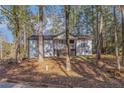 Charming home featuring a quaint front porch and stairs nestled within a wooded landscape at 7155 Pineneedle Drive Sw, Covington, GA 30016