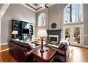 Bright living room with soaring ceilings, hardwood floors, built-in shelving, and a cozy fireplace at 825 Autry Landing Cir, Alpharetta, GA 30022