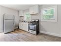 This light and airy kitchen boasts stainless steel appliances, clean white cabinets, and sleek hardwood flooring at 2825 3Rd Sw Ave, Atlanta, GA 30315