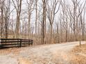 Gravel driveway leading to the property, bordered by a wooden fence and bare trees at 1344 Brushy Mountain Rd, Rockmart, GA 30153