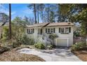 Beautiful white home with green shutters, complemented by mature trees and a well-maintained lawn at 2484 Oldfield Nw Rd, Atlanta, GA 30327