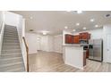 Open-concept living room with wood floors, stainless steel appliances, and staircase at 556 Oakside Pl, Acworth, GA 30102