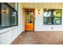Inviting front porch featuring a stylish wood door, black-trimmed windows, and warm lighting at 353 Troy Se St, Atlanta, GA 30315