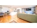 Bright open-concept living room showcasing hardwood floors, a dining area, a kitchen bar, and a comfortable lounge at 2411 Fair Ln, Decatur, GA 30032