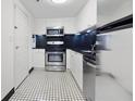 Compact kitchen with stainless steel appliances, black tiled backsplash, and black and white floors at 1501 Clairmont Rd # 1027, Decatur, GA 30033