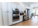 Chef's kitchen with built-in ovens, modern stainless steel refrigerator, and ample cabinet space at 592 Moreland Ne Ave, Atlanta, GA 30307