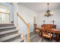 Bright dining room with classic chandelier, light gray flooring, and stairway nearby at 2543 Oak Creek Ln, Conyers, GA 30094