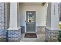 Inviting front entry with a gray painted door, brick columns, and a stylish welcome mat at 1100 N North Village Drive Dr, Decatur, GA 30032