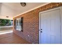 Inviting front porch featuring brick accents, a white door, and a charming outdoor space at 26 Wey Bridge Ct, White, GA 30184