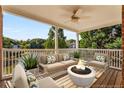 Beautiful covered patio with a fire pit and view of the lake and trees at 5080 Riverlake Dr, Peachtree Corners, GA 30097
