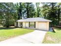 Exterior view of this charming home with a long driveway and well manicured front yard at 8169 Kendrick Rd, Jonesboro, GA 30238