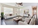 Bright living room features neutral walls, dark floors, ceiling fan, and updated lighting at 8169 Kendrick Rd, Jonesboro, GA 30238