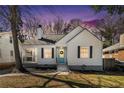 Charming white cottage-style home featuring a covered porch and a light blue front door at twilight at 1547 Melrose Sw Dr, Atlanta, GA 30310