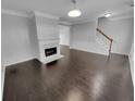 Open living room with fireplace, hardwood floors, and a view into the dining area at 1235 Park Pass Way, Suwanee, GA 30024