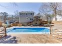 Backyard view featuring a refreshing swimming pool and a spacious wooden deck with a multi-story home backdrop at 2011 Two Springs Way, Lawrenceville, GA 30043