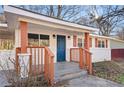 Inviting front porch with a blue front door, white brick, and brown pillars at 248 N Lake Dr, Jonesboro, GA 30236