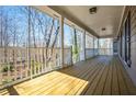 View of the spacious, covered porch overlooking a wooded backyard at 2704 Loring Nw Rd, Kennesaw, GA 30152