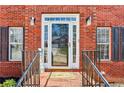 Close-up of the front door framed by stylish sconces and well-maintained brickwork and black metal railings at 569 Alexander Farms Sw Vw, Marietta, GA 30064