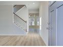 Bright foyer with wood-look floors, staircase, and views into an open-concept living area at 90 Barge Ln, Covington, GA 30016