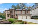 Elegant brick home featuring a three-car garage, manicured lawn, and a charming double-door entrance at 2146 Greensward Ne Dr, Atlanta, GA 30345