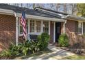 Inviting front porch with a cozy bench, American flag, and neatly trimmed bushes enhancing curb appeal at 6830 Sunny Brook Ln, Atlanta, GA 30328